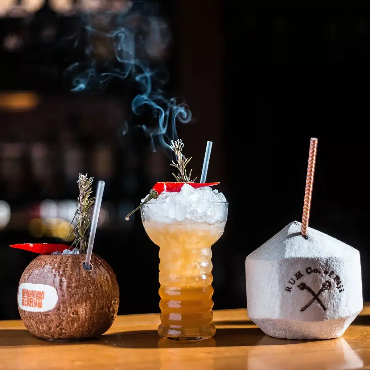 A classic Dark 'n' Stormy cocktail with dark rum and ginger beer served in a tropical setting
