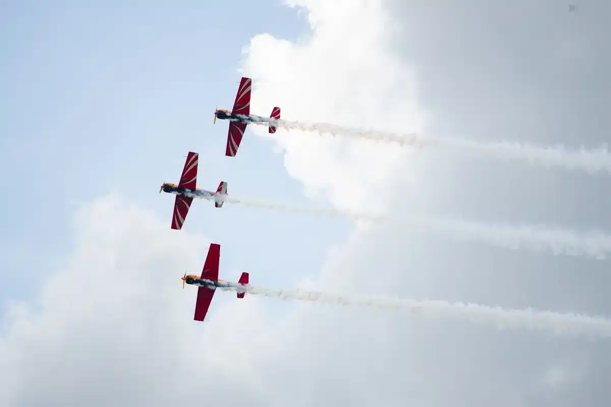 Acrobatic aircraft performing over a seaside crowd during an air display