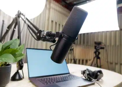 Person speaking into microphone with social media comment bubbles visible