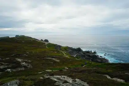 Rainy weather over green Irish countryside with clouds and umbrella