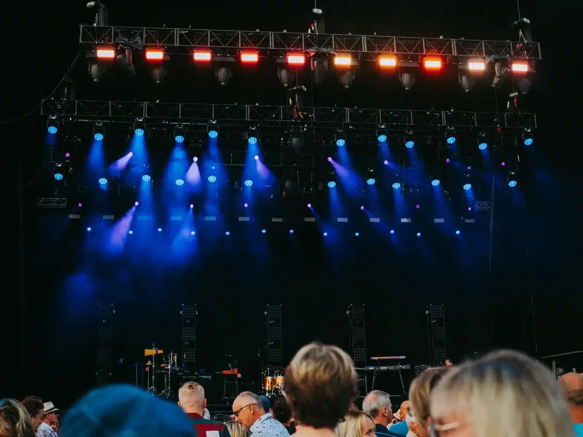 Stadium concert stage with dramatic lighting and energetic crowd atmosphere during a live performance
