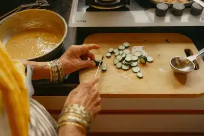 Hands preparing traditional Pakistani food with spices and ingredients on a kitchen counter