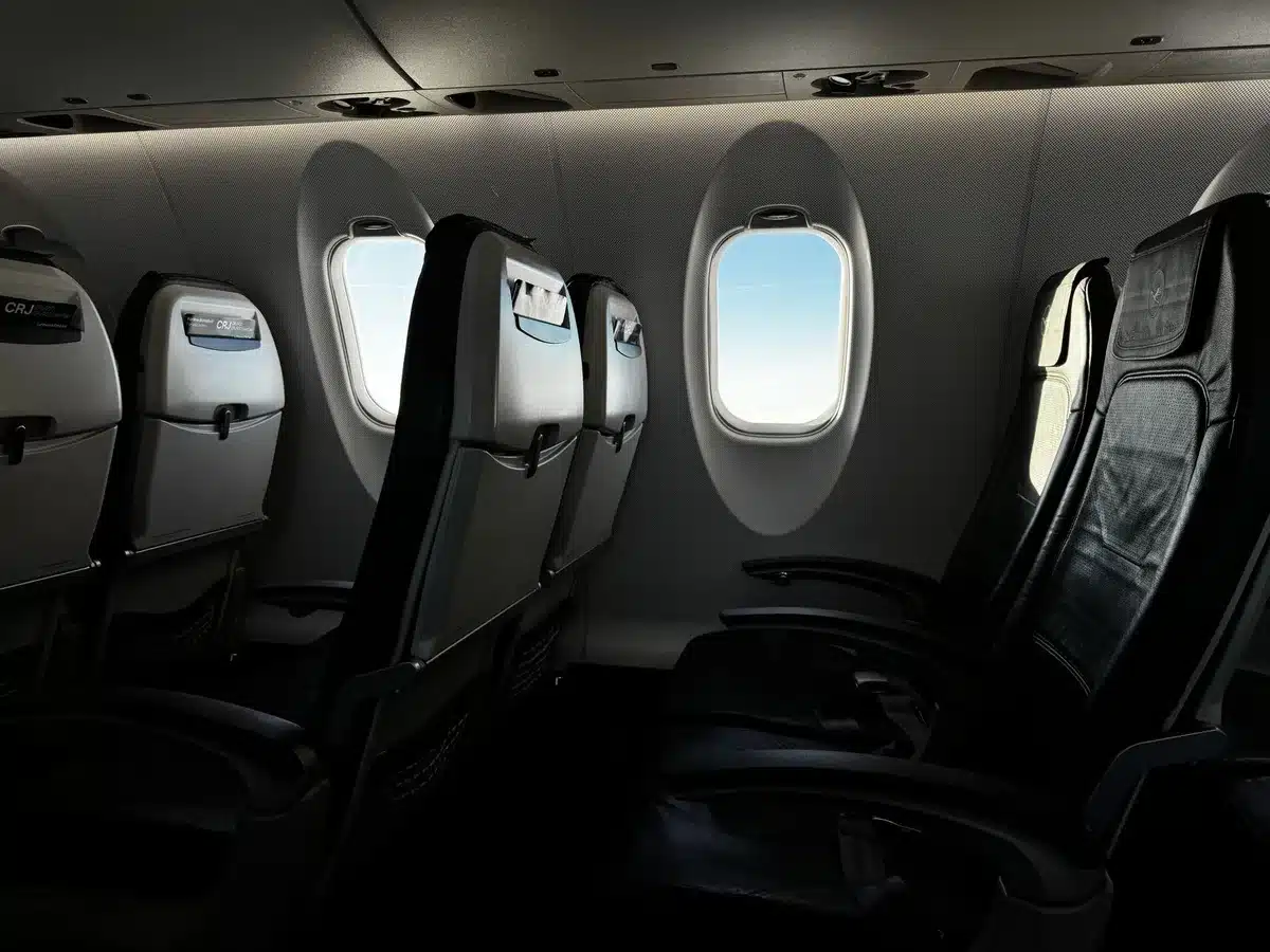 Interior of an airplane cabin showing rows of seats and the controlled cabin environment