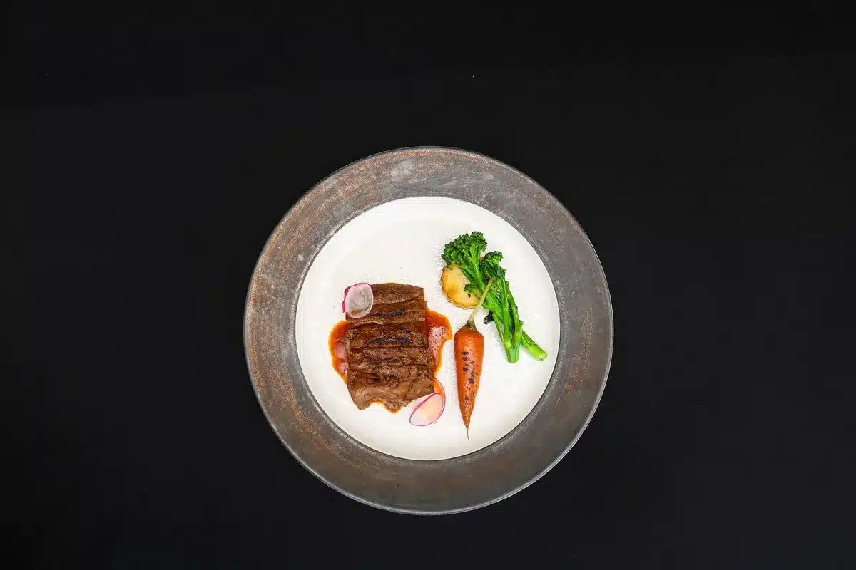 A chef plating a dish with seasonal, locally sourced ingredients