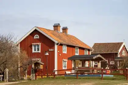 A quiet country road leading to a small village with a café glowing warmly among rural surroundings