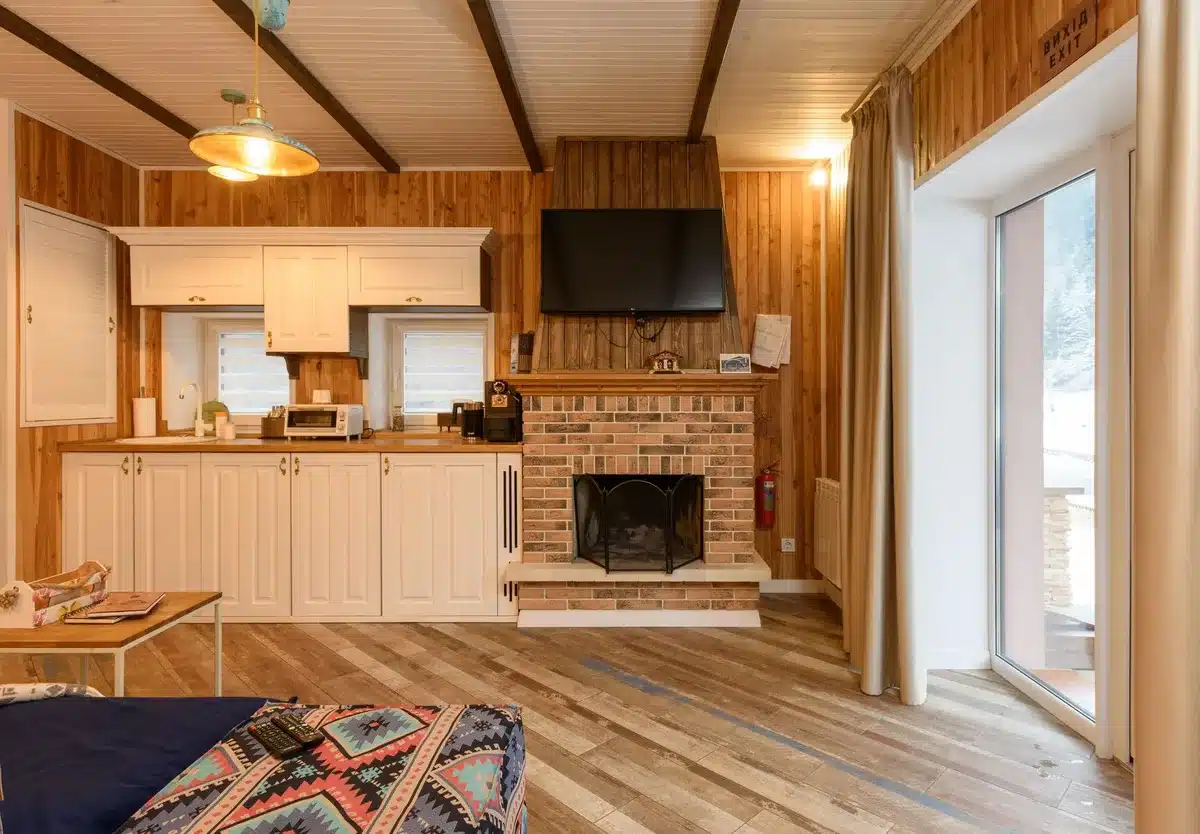 Tús agus soilse tine i gcabin nua-aoiseach ar an spéir dorcha