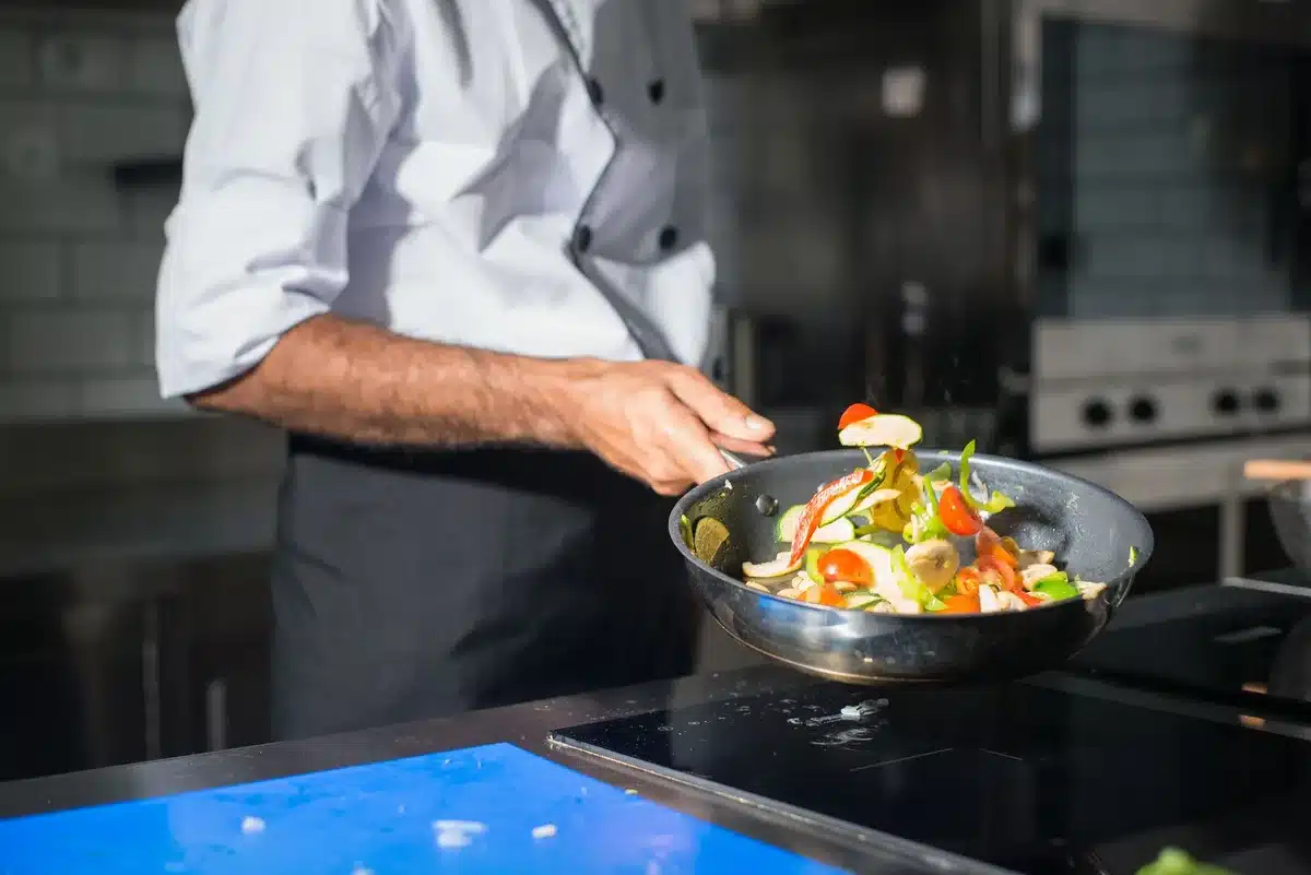 Chef demonstrating cooking technique with fresh ingredients in a kitchen
