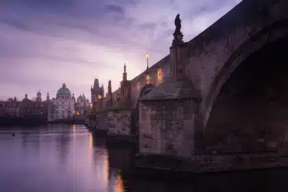 Charles Bridge in Prague at dusk with baroque statues and river views