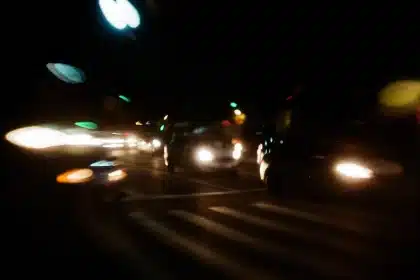 Nachtszene auf einer Landstraße mit Unfallwrackteilen und Notfallfahrzeugen