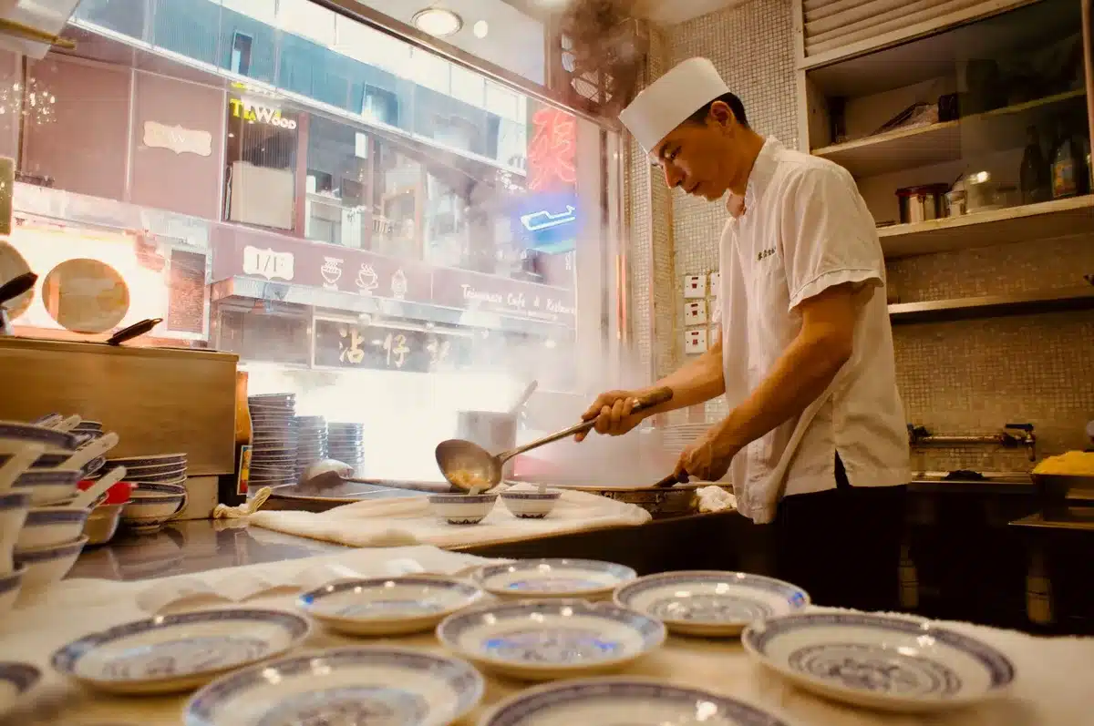 Chef preparing Hong Kong-inspired dishes in a restaurant kitchen