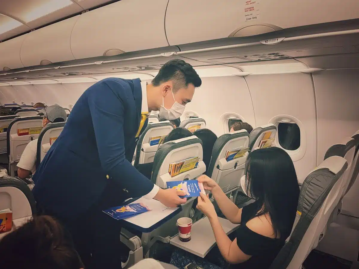 Cabin crew member speaking with a passenger in an aircraft cabin