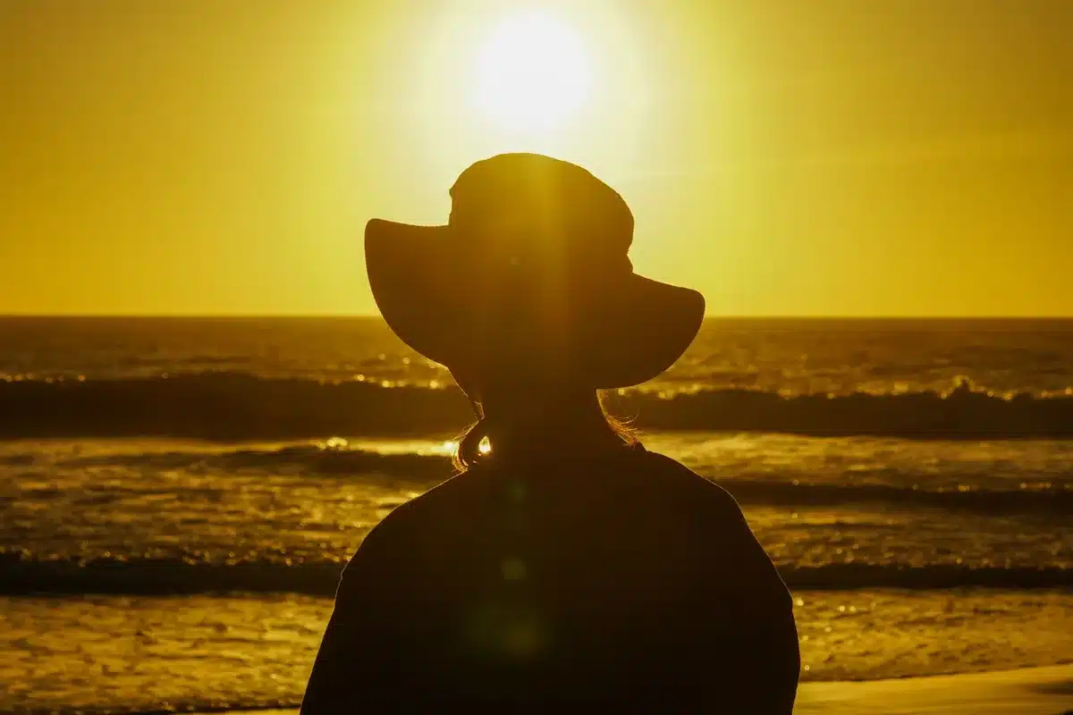 Person watching the sunset over water during golden hour at dusk