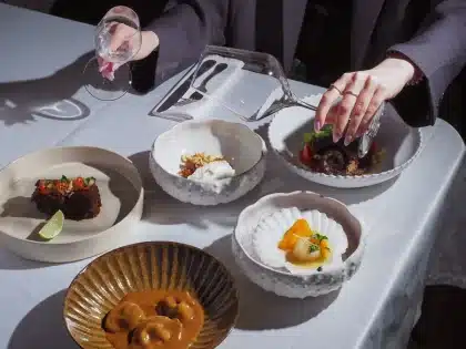 Elegantly plated fine dining dish with wine glass in an upscale restaurant setting