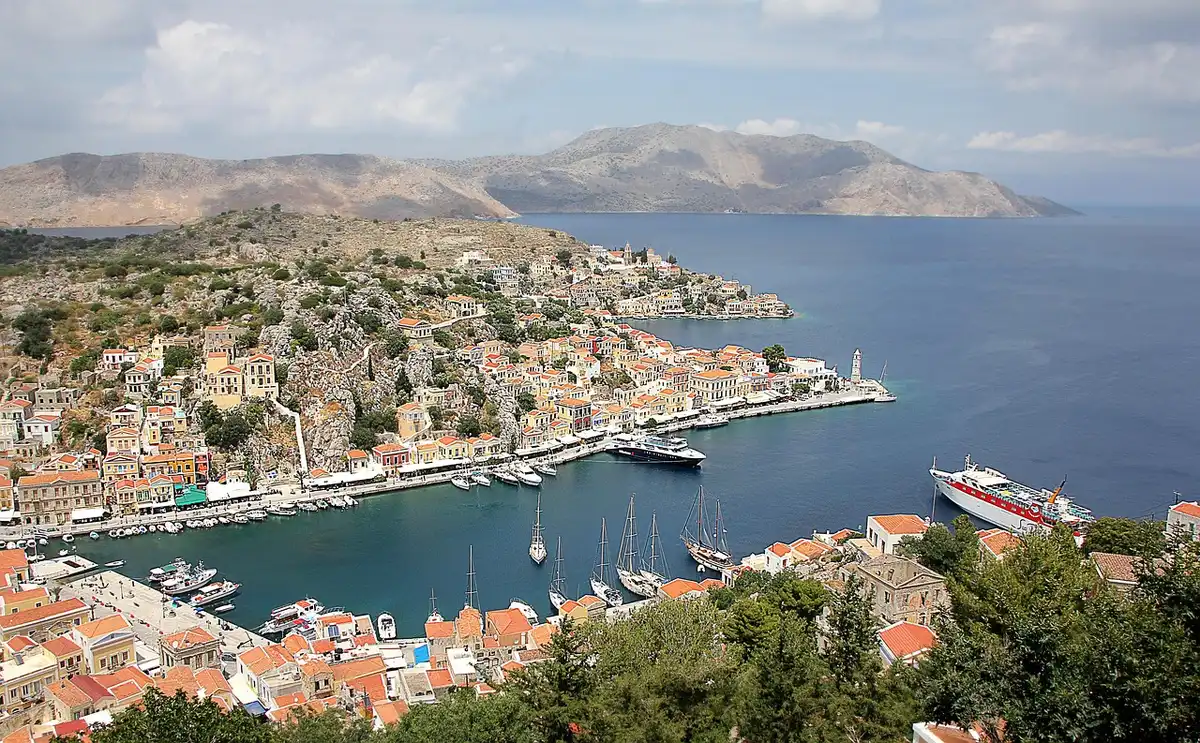 Traditional ferry boat sailing between Greek islands with clear blue sea and distant coastline