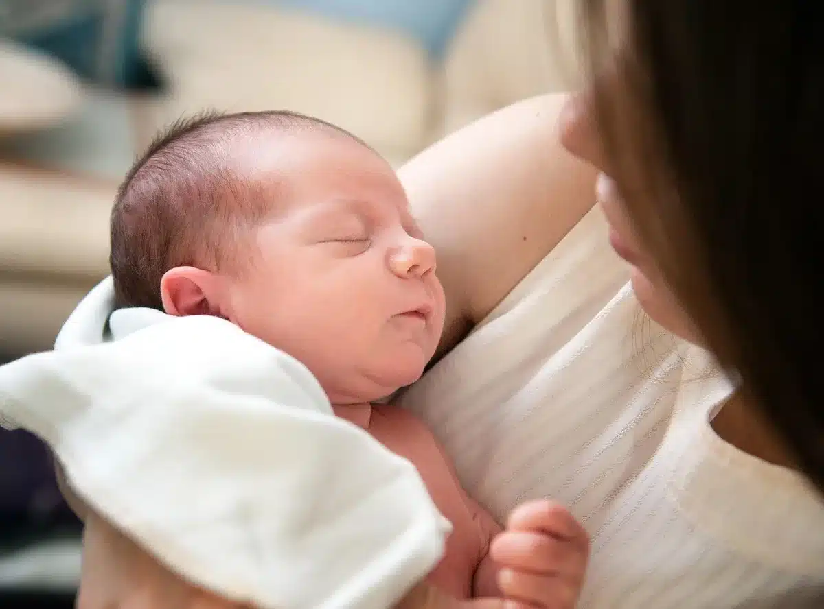 New parents beside a bassinet in a cozy home setting