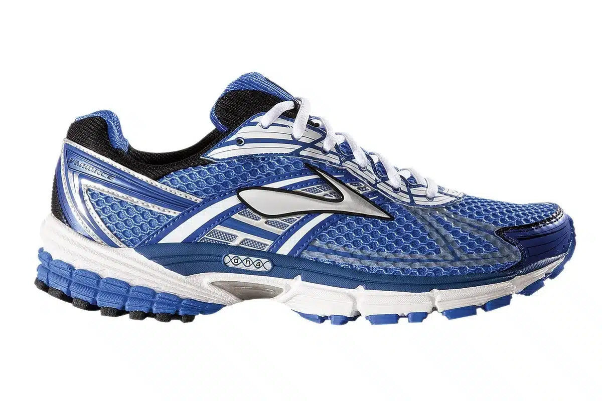 Specialist fitting shoes in store with customer trying on running trainers