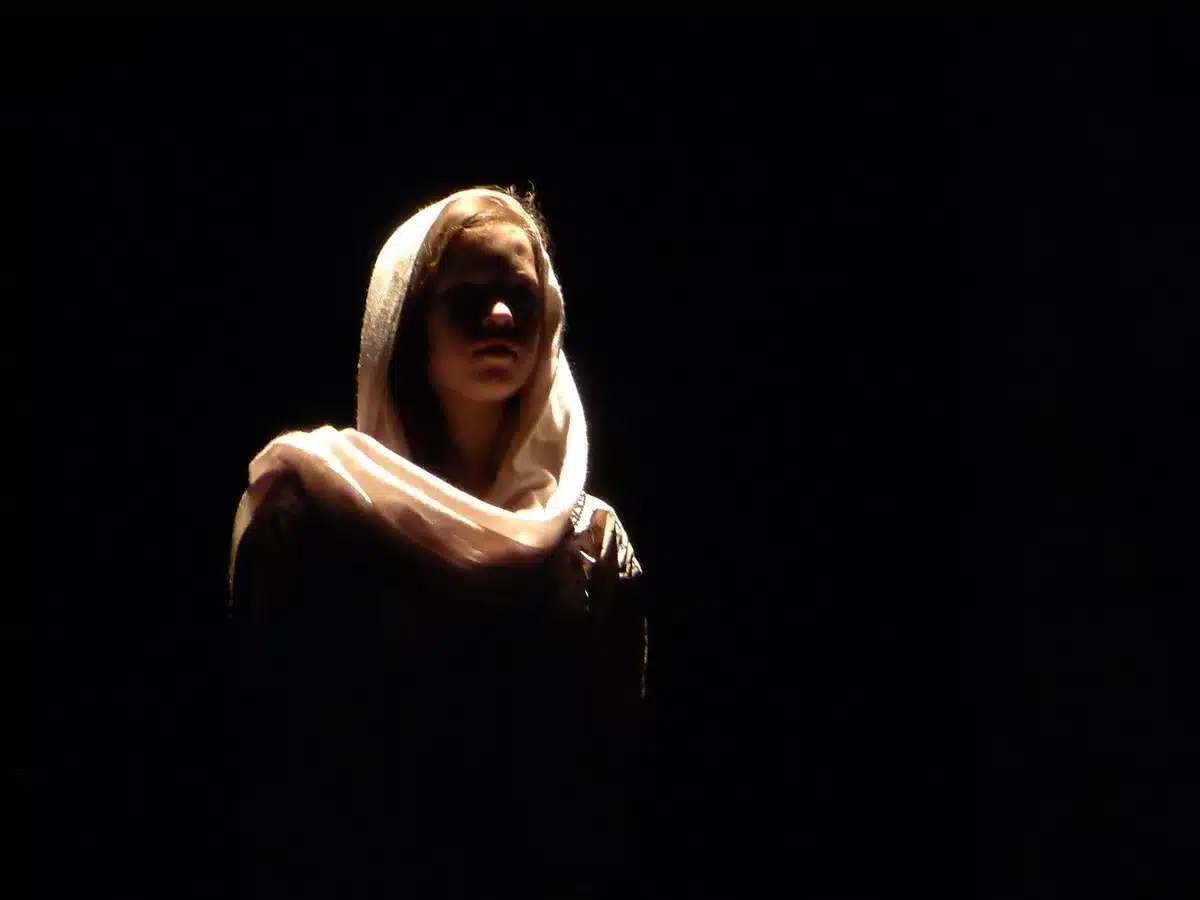 Actress on a sunlit stage accepting an award at a film ceremony