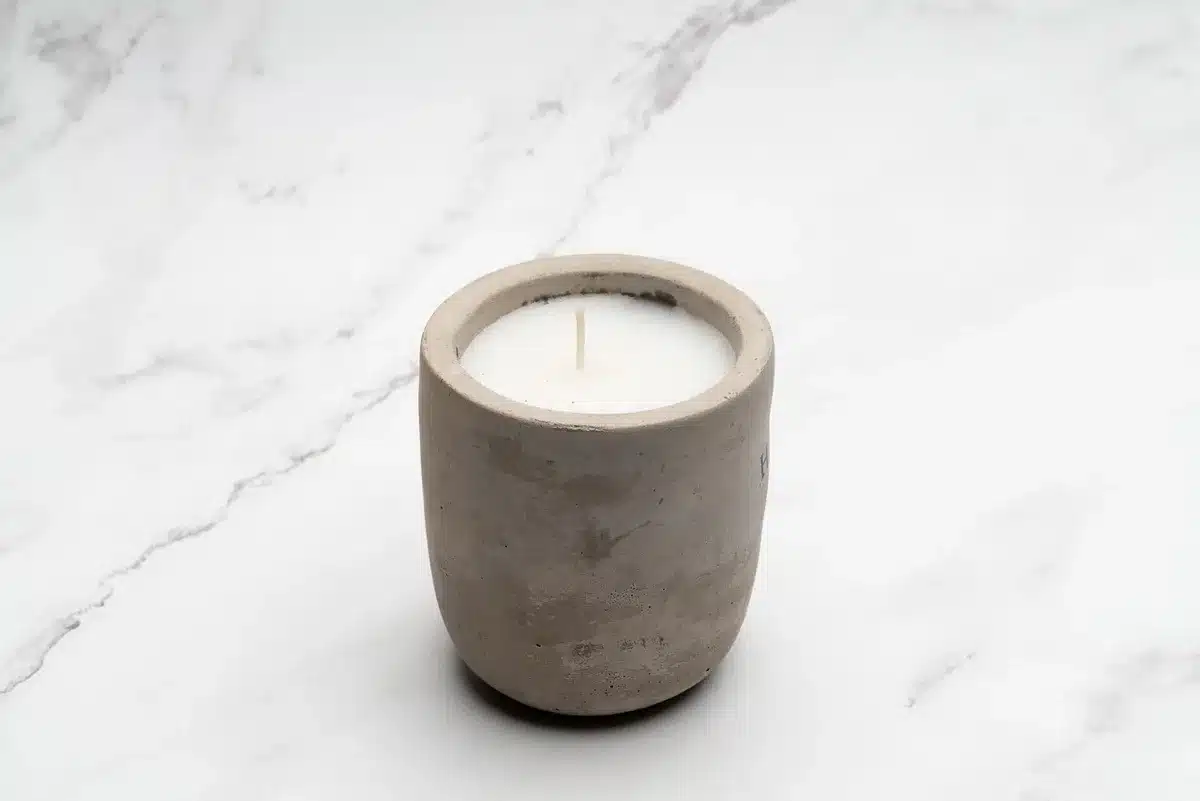 Minimalist candle and small booklet on a shelf showing home scent options