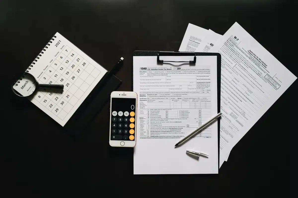 Calculator and tax papers on a sunlit desk