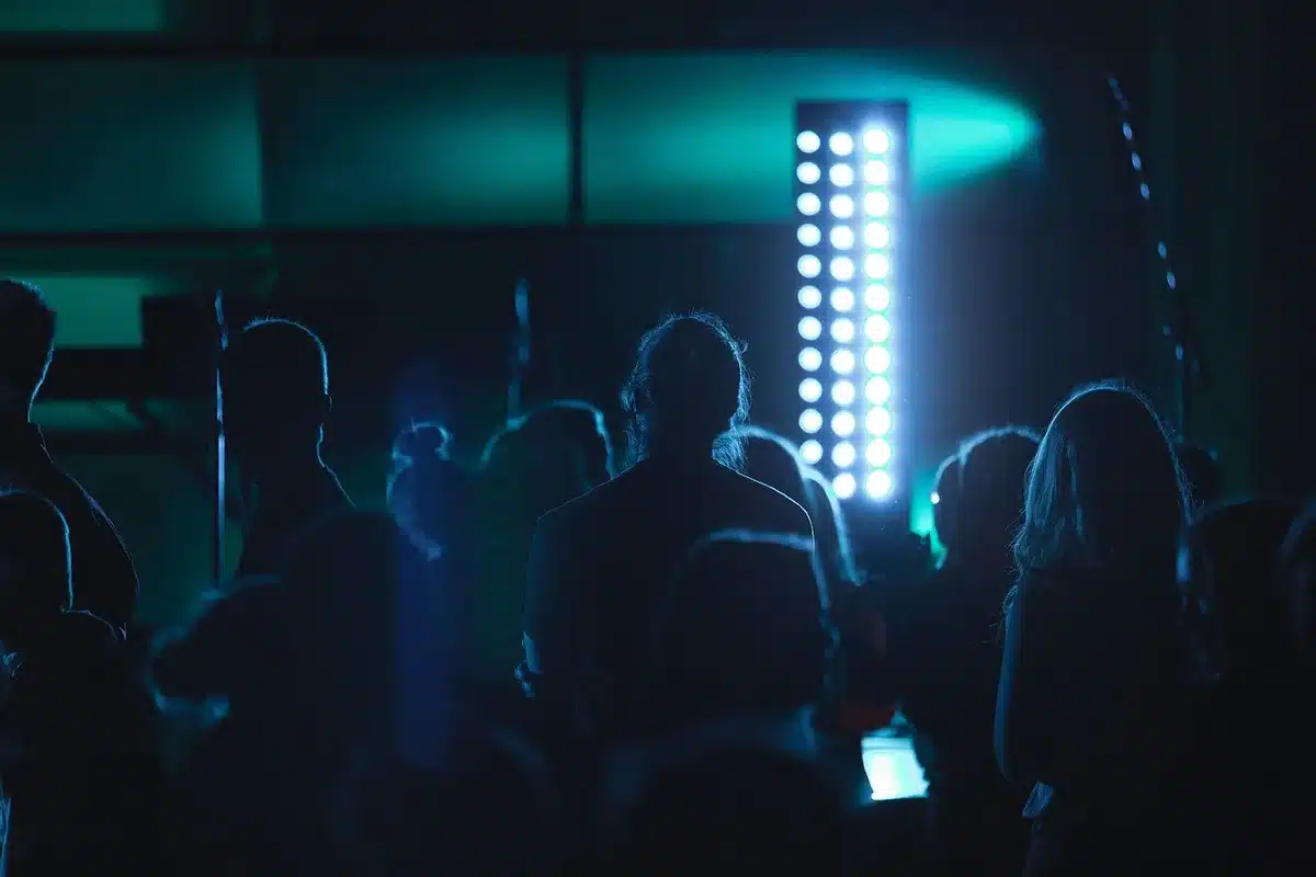 Fans cheering and raising phones during opening songs at an arena concert