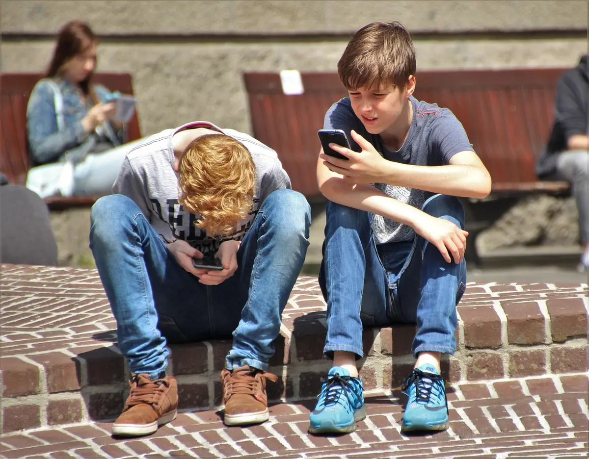 Person looking at phone with frustrated body language while scrolling social media