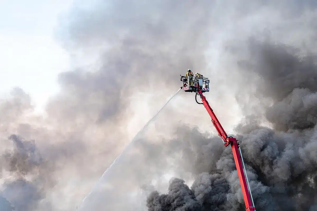 Firefighters working outside an isolated rural house in daylight