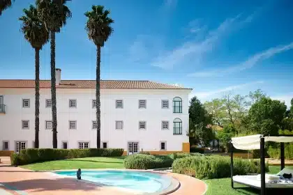 Sunlit hotel courtyard with castle-style building and resort lawn in daylight