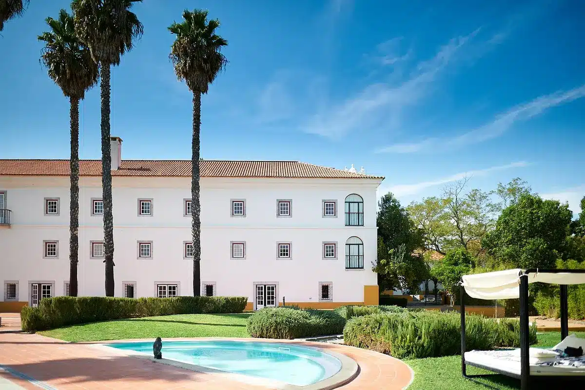 Sunlit hotel courtyard with castle-style building and resort lawn in daylight