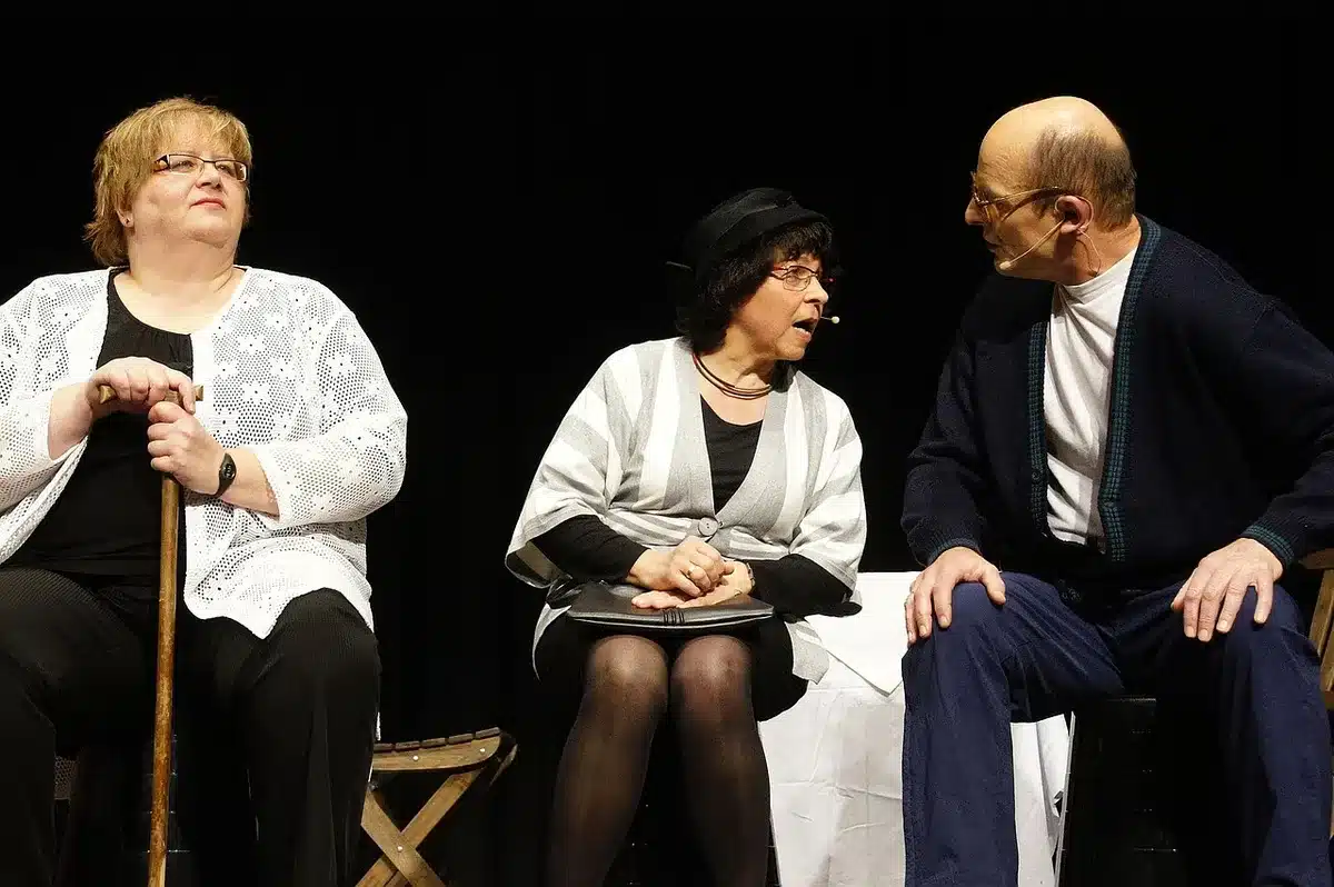 Two anonymous actors' hands exchanging a script in a rehearsal room
