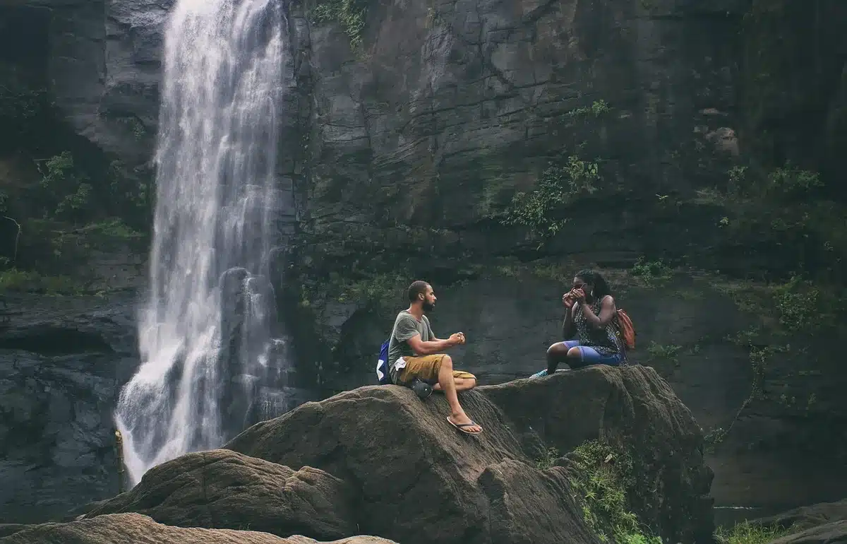 Couple reaching for a rock-climbing hold outdoors