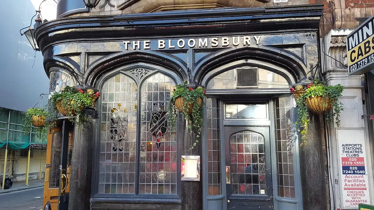 Daylight pub entrance with a breathalyser-style terminal on a counter and a patron's hand reaching