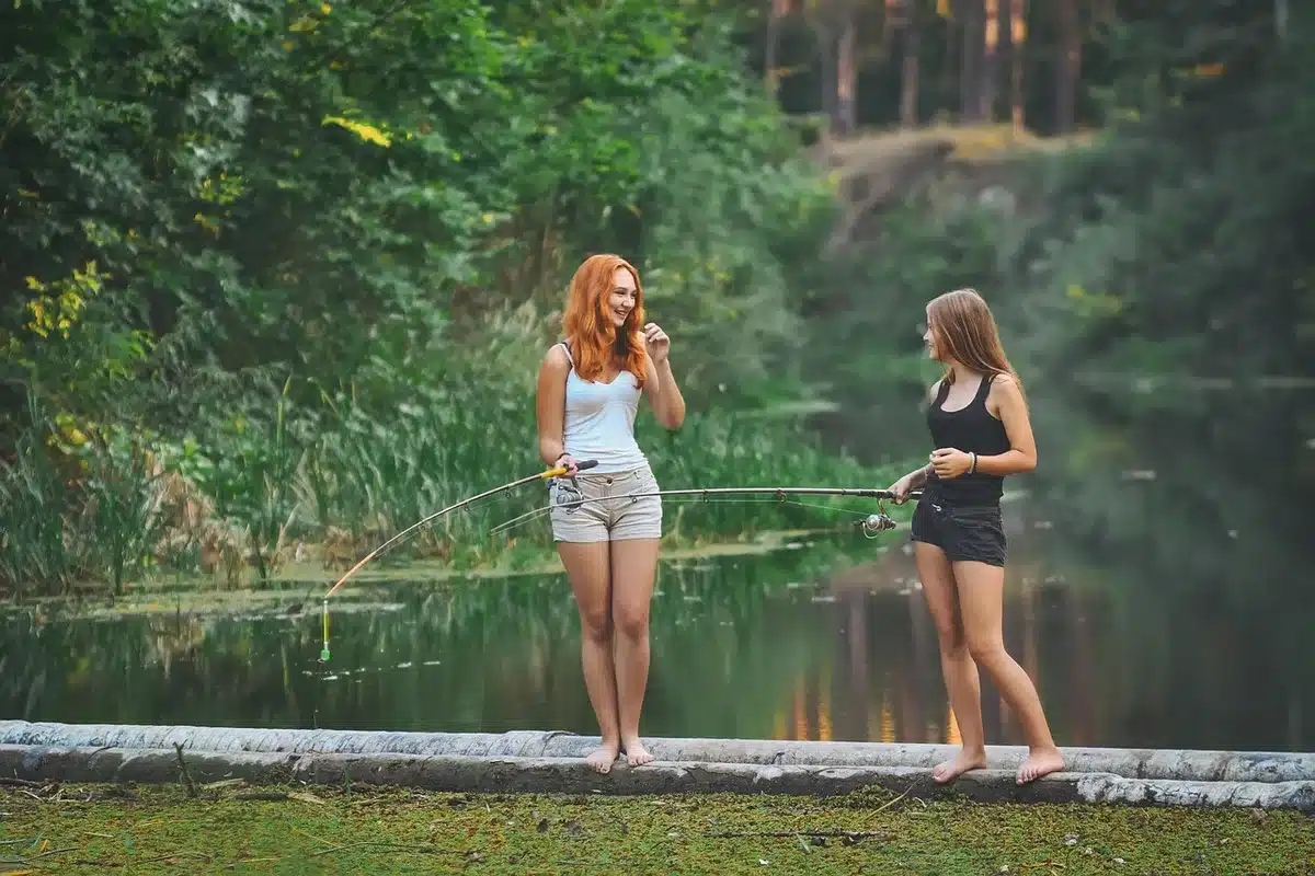 Two friends laughing together outdoors near a festival site