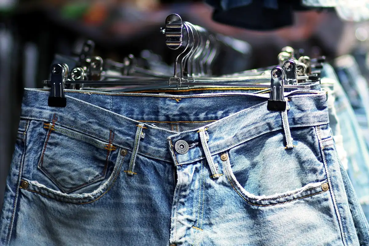 Racks of designer and pre-loved clothing at a busy sale